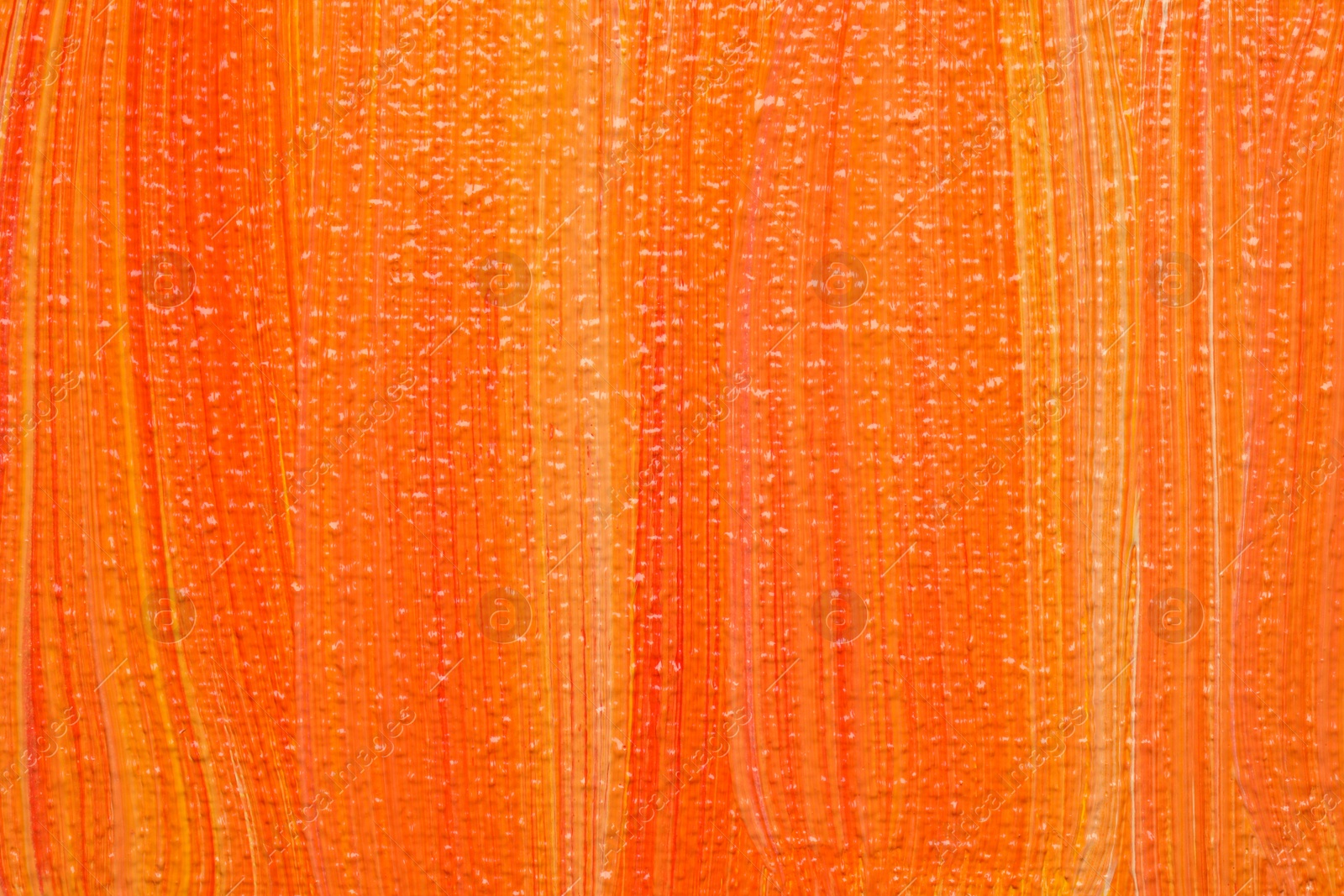 Photo of Beautiful strokes of orange oil paints as background, closeup