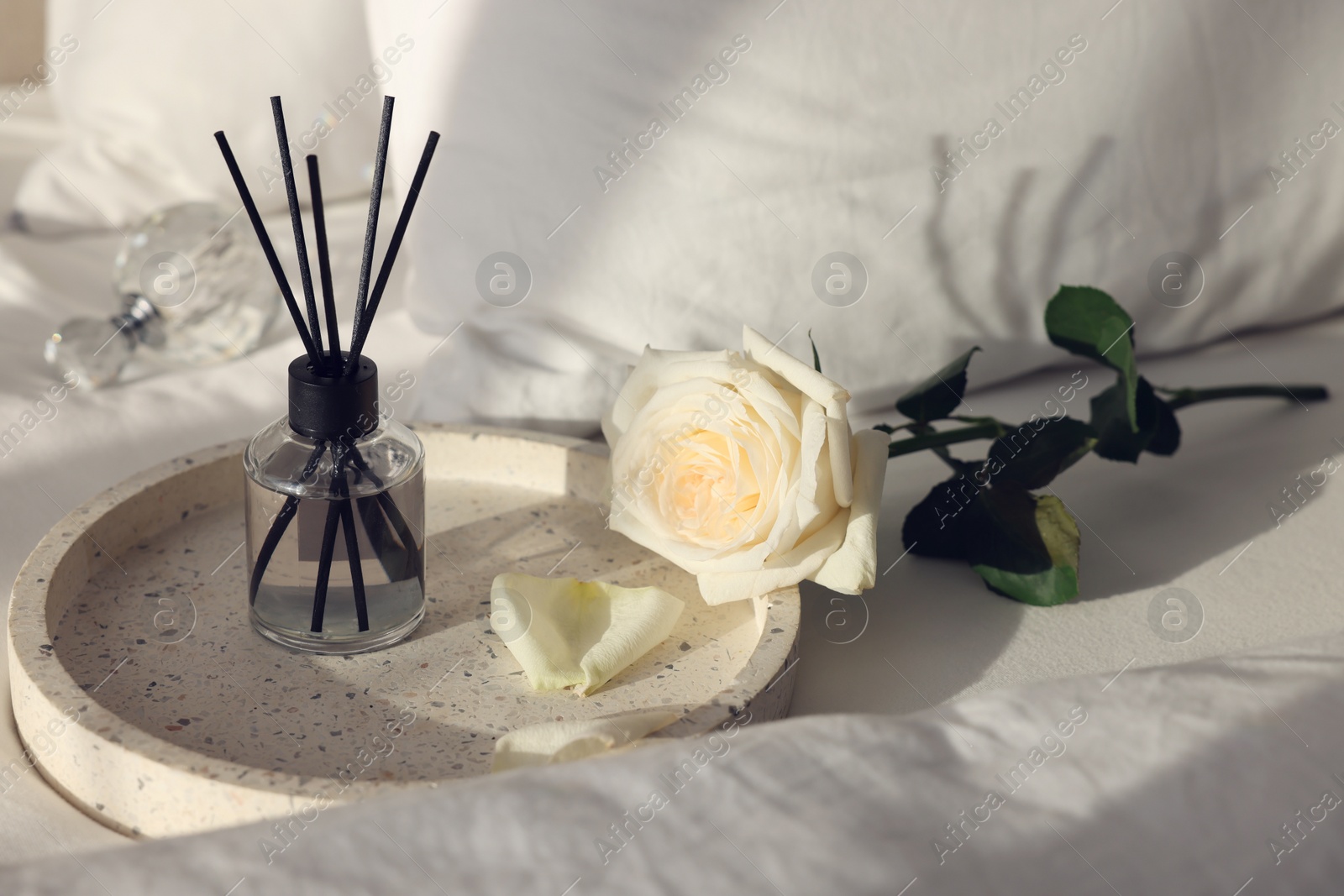 Photo of Aromatic reed air freshener and flower on bed