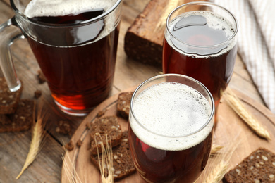 Photo of Delicious kvass, bread and spikes on wooden table