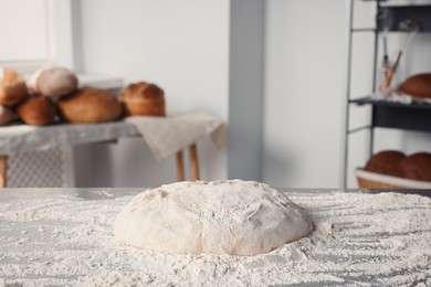 Fresh dough with flour on table in kitchen