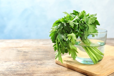 Fresh green parsley in glass on table. Space for text