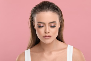 Beautiful woman with makeup on pink background