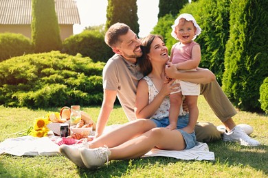 Happy family having picnic in garden on sunny day