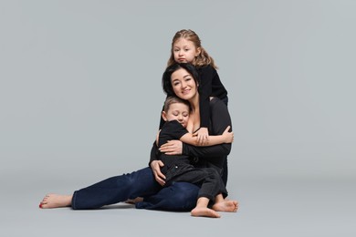 Photo of Little children with their mother on grey background