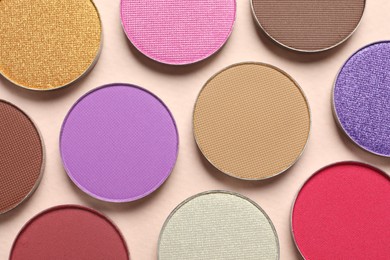 Photo of Different beautiful eye shadows on beige background, flat lay