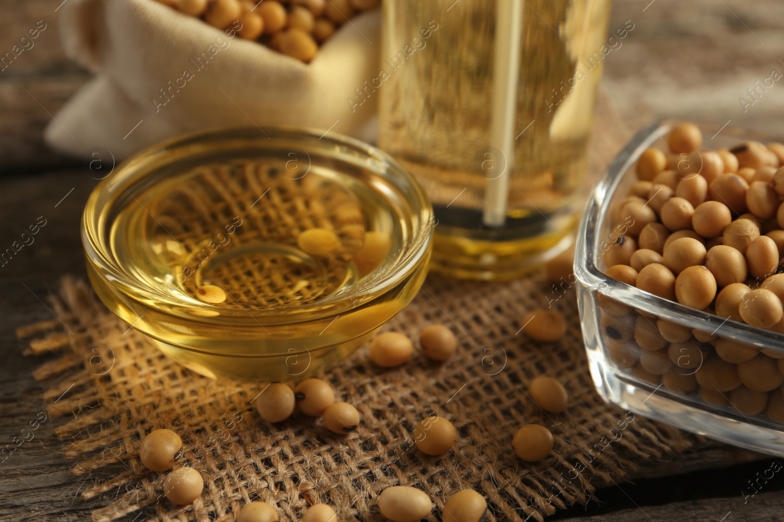 Photo of Composition with soybean oil on wooden table, closeup