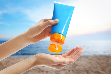 Image of Young woman applying sun protection cream near sea, closeup