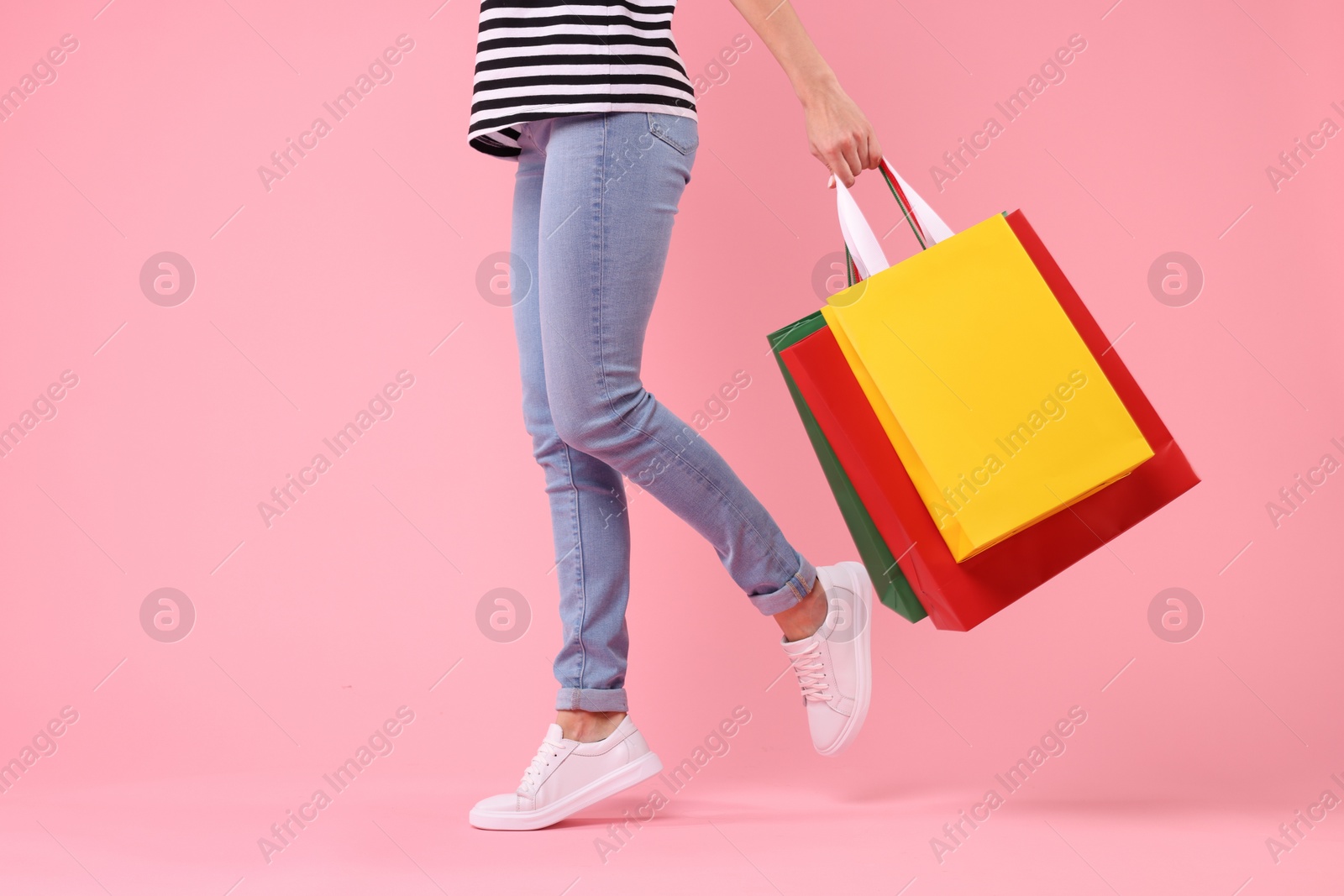 Photo of Woman with shopping bags on pink background, closeup