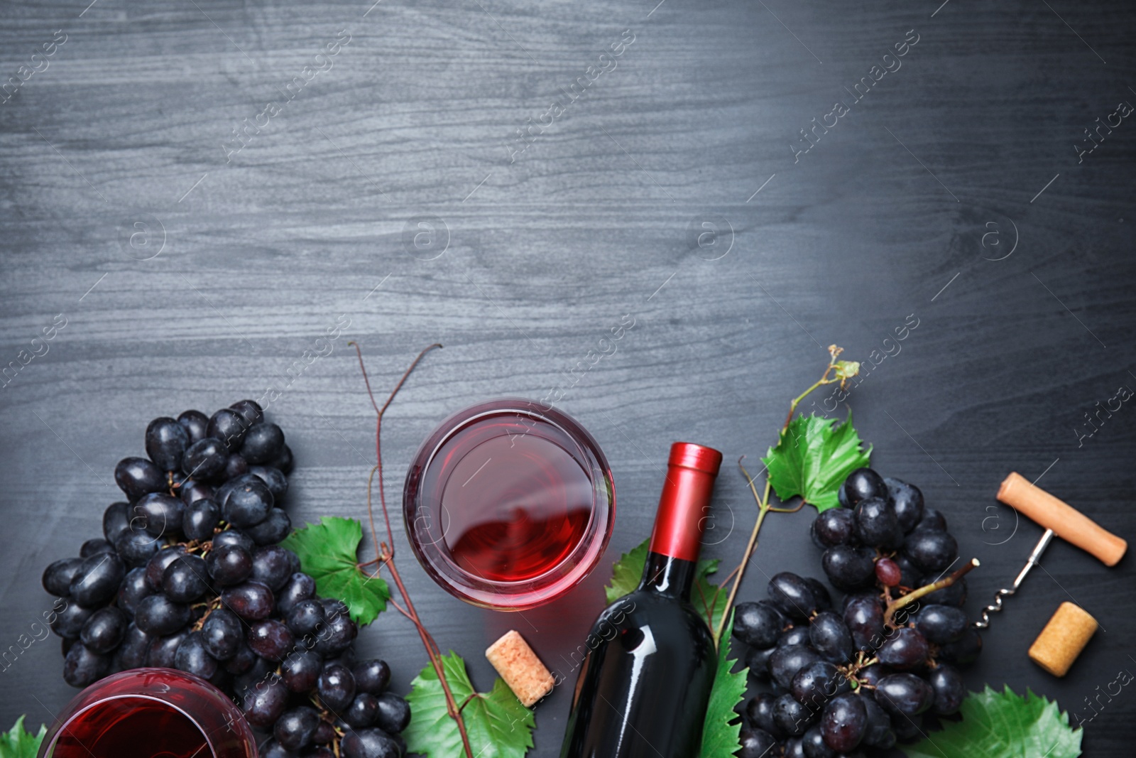 Photo of Flat lay composition with fresh ripe juicy grapes and space for text on wooden background