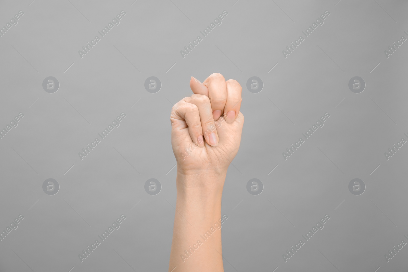 Photo of Woman showing N letter on grey background, closeup. Sign language