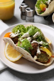 Photo of Delicious fresh vegan taco served on light grey marble table