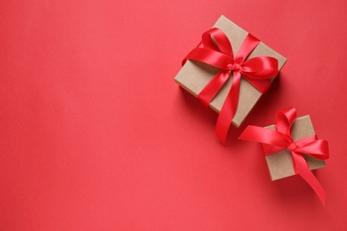 Photo of Beautiful gift boxes on red background, flat lay. Space for text