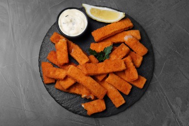 Photo of Tasty fresh fish fingers served on black table, top view