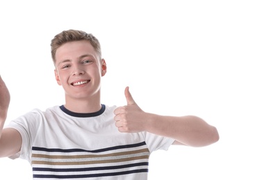 Photo of Happy teenage boy taking selfie on white background