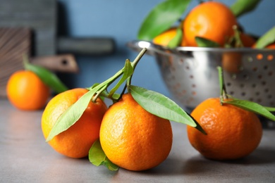 Photo of Tasty ripe tangerines on table. Citrus fruit