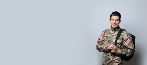Photo of Cadet with backpack on light grey background. Military education