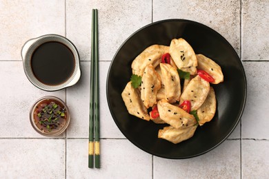 Photo of Delicious gyoza (asian dumplings) served on light tiled table, flat lay
