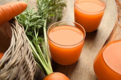 Photo of Freshly made carrot juice on wooden table