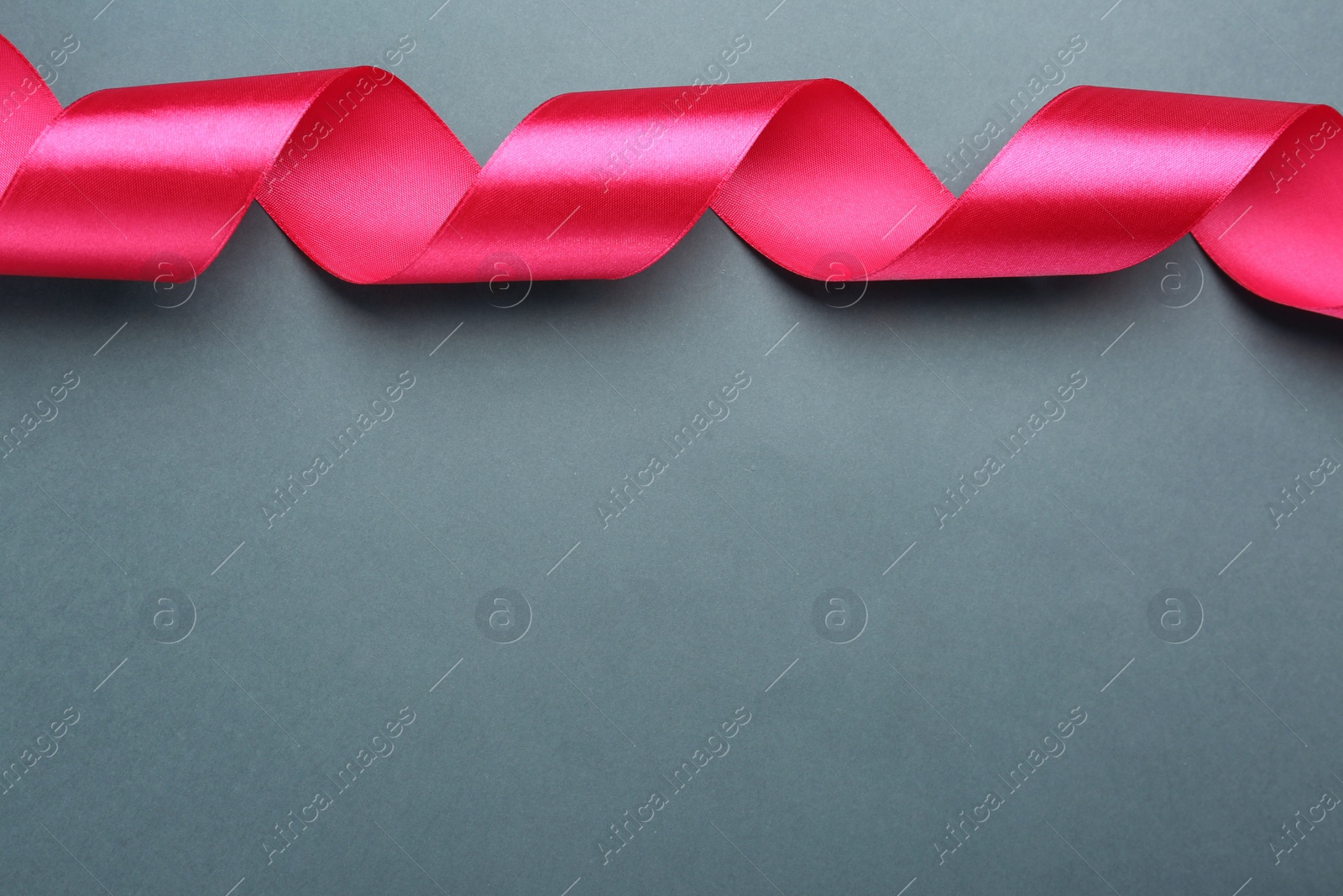 Photo of Beautiful pink ribbon on grey background, top view. Space for text