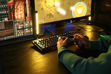 Photo of Man playing video games with controller at table indoors, closeup