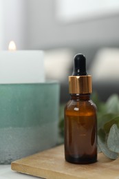 Aromatherapy. Bottle of essential oil and eucalyptus leaves on table