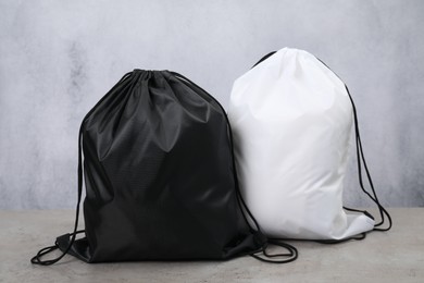 Photo of Two drawstring bags on grey textured table