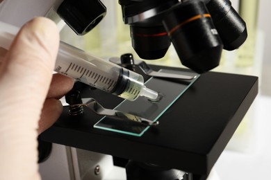 Photo of Doctor dropping urine on microscope glass slide, closeup