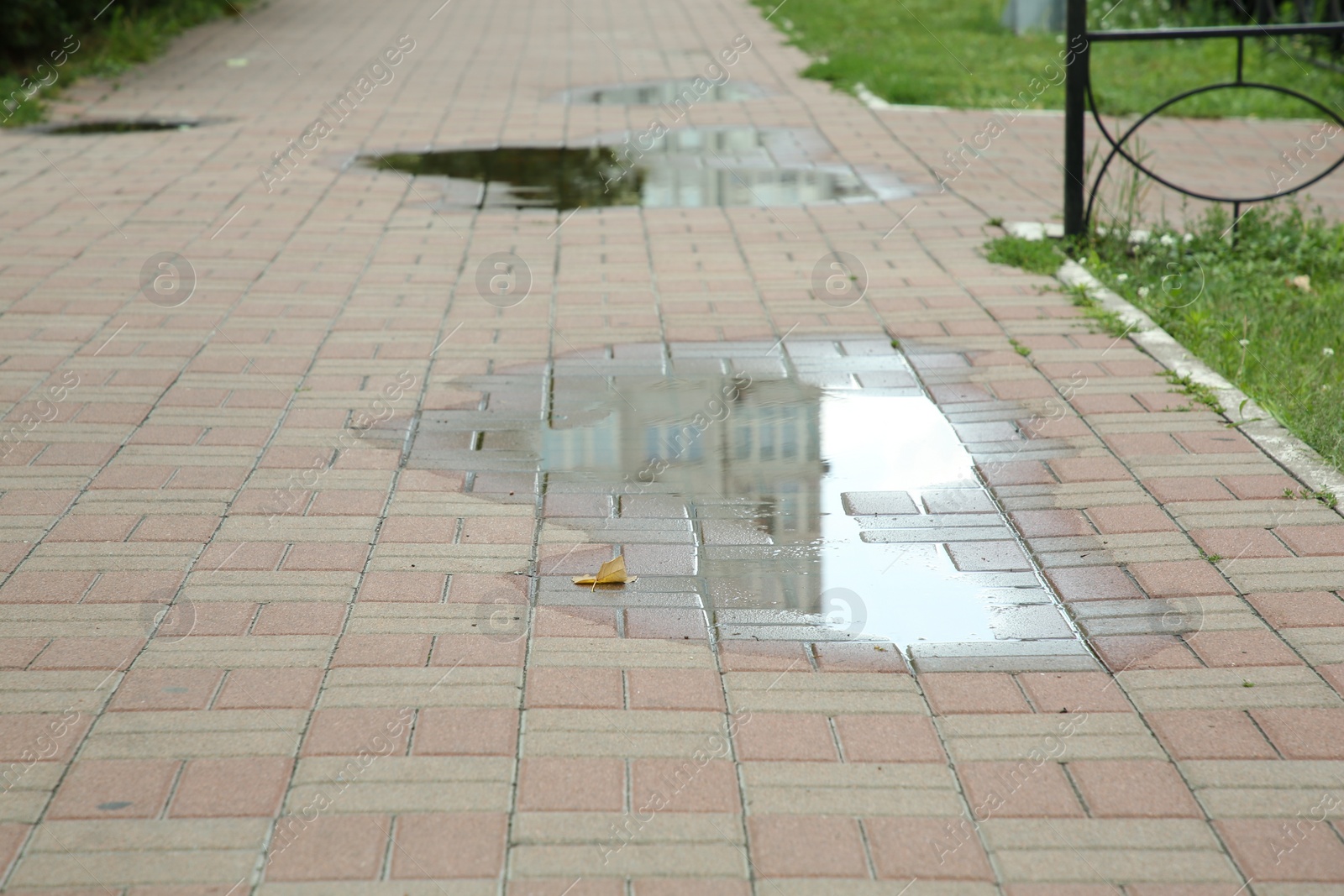 Photo of Puddle after rain on street tiles outdoors