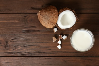 Photo of Glass of coconut milk and fresh nuts on wooden background, top view