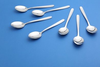 Photo of Composition with clean tablespoons on color background