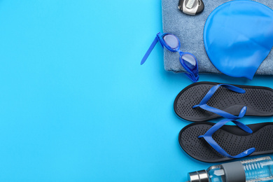 Photo of Flat lay composition with swimming accessories on blue background. Space for text