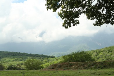 Photo of Picturesque view of mountains and green meadow