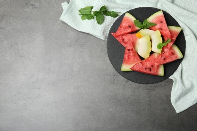 Photo of Watermelon and melon slices on grey background, flat lay. Space for text