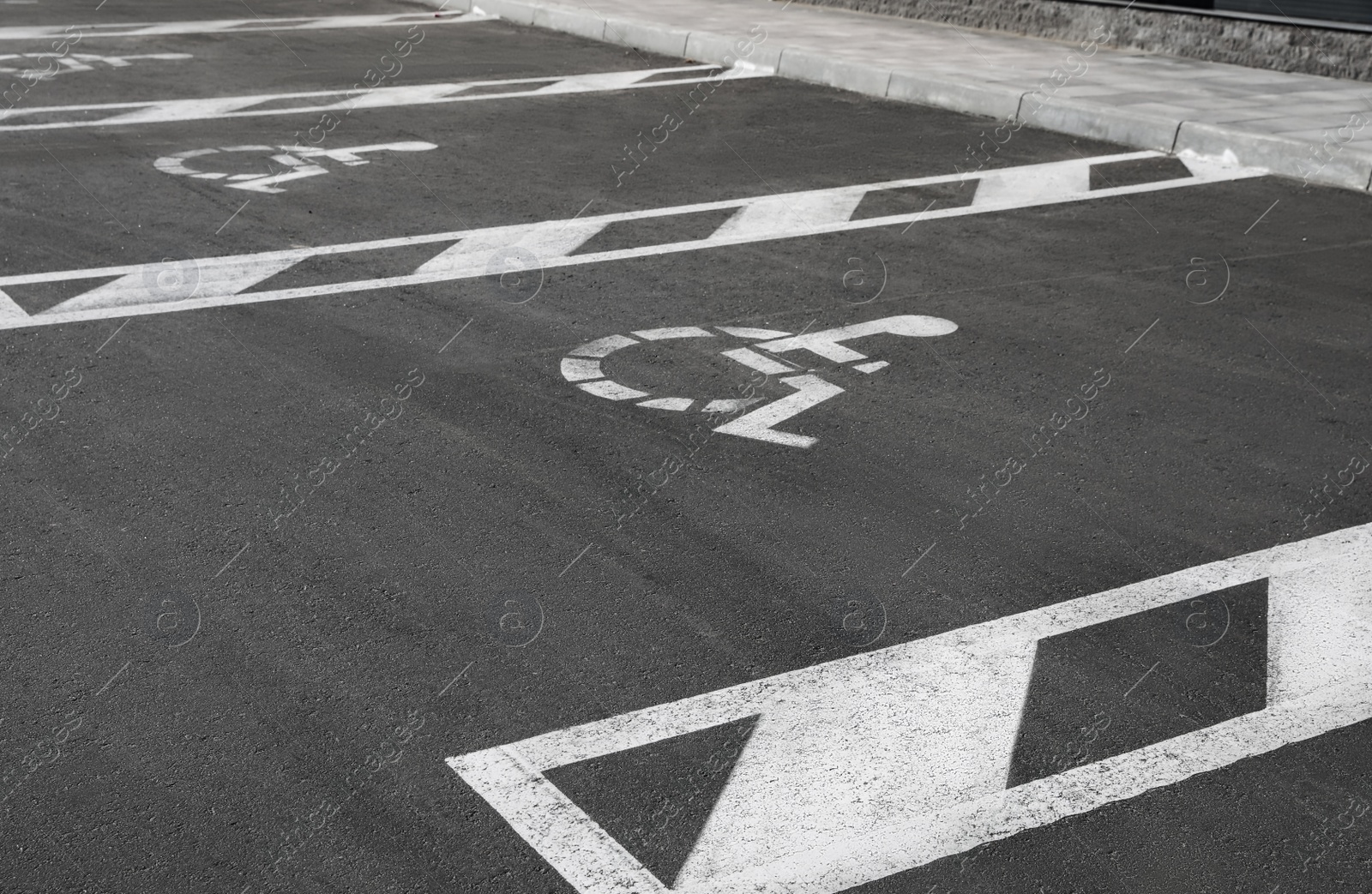 Photo of Car parking lot with wheelchair symbols outdoors