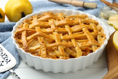 Photo of Tasty homemade quince pie on white wooden table, closeup