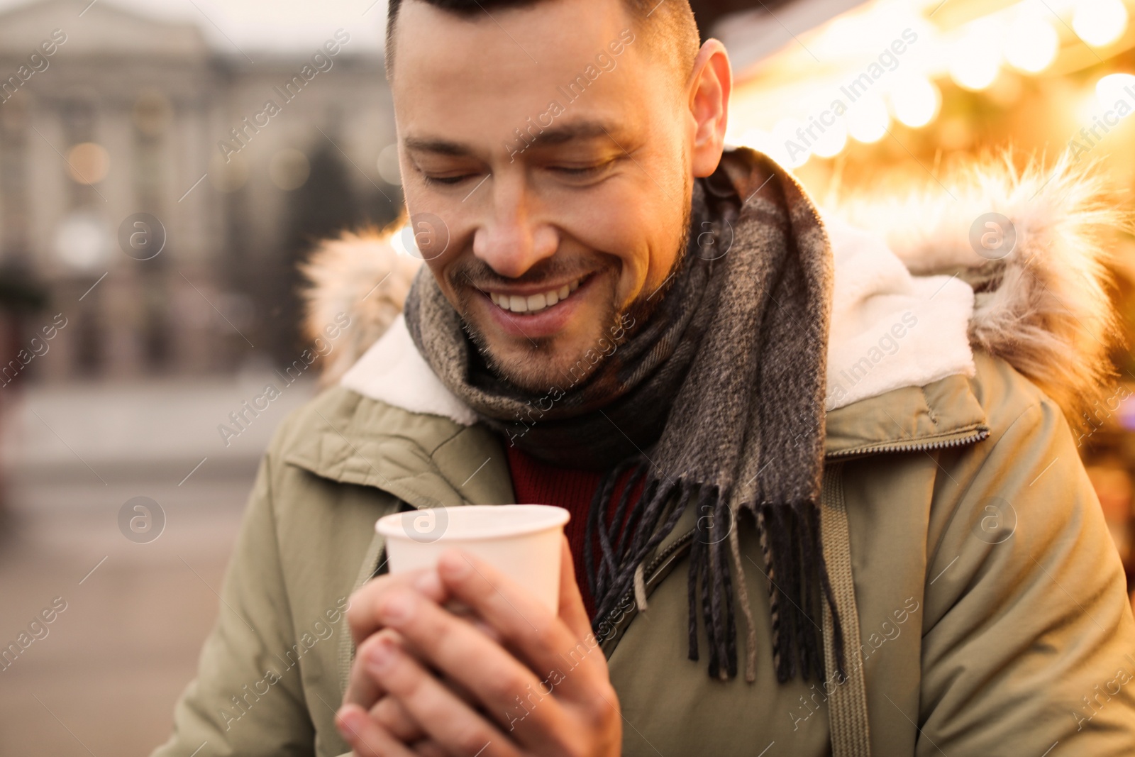 Photo of Happy man with mulled wine at winter fair