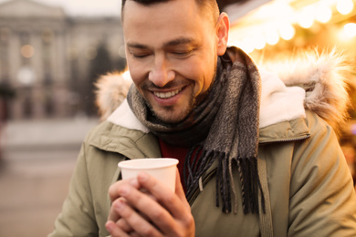 Happy man with mulled wine at winter fair