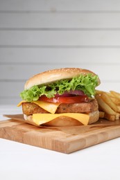 Photo of Delicious tofu burger served with french fries on white table