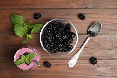 Photo of Flat lay composition with fresh blackberries and smoothie on wooden table