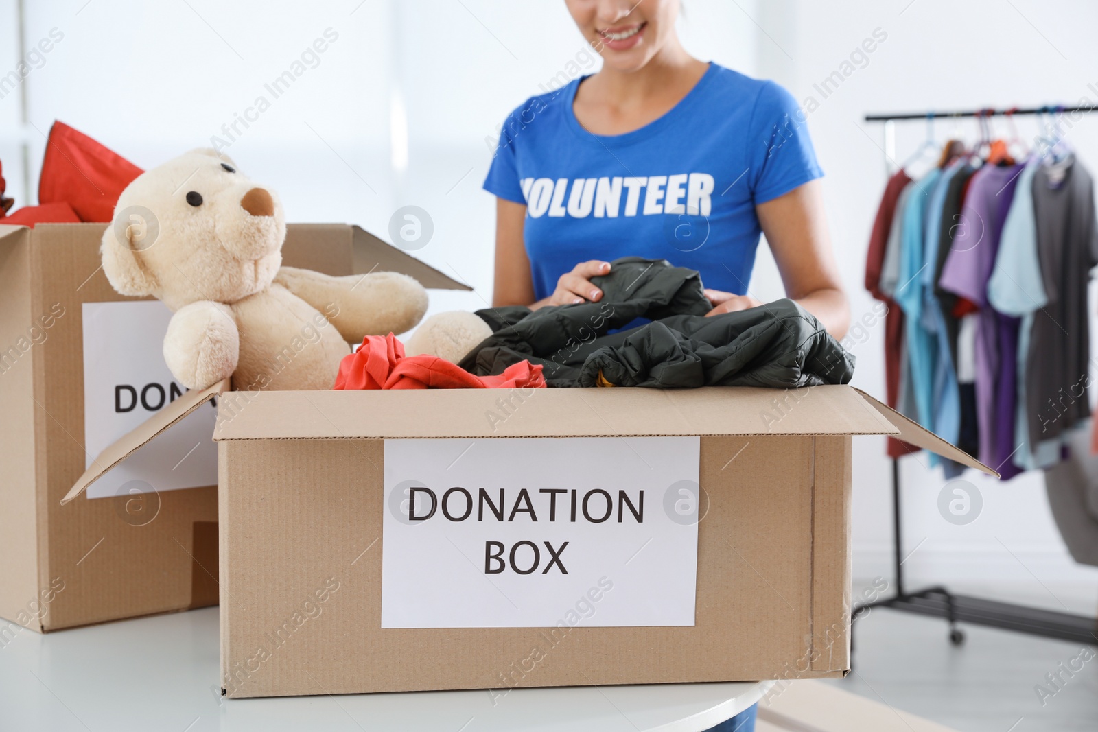 Photo of Female volunteer collecting donations at table indoors