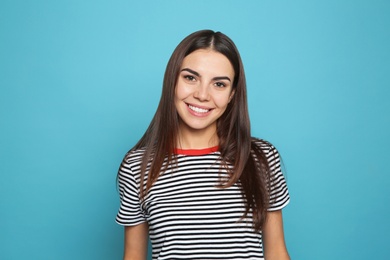 Portrait of young woman laughing on color background