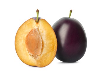 Whole and cut ripe plums on white background