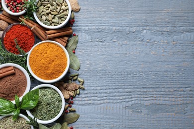 Photo of Different natural spices and herbs on grey wooden table, flat lay. Space for text