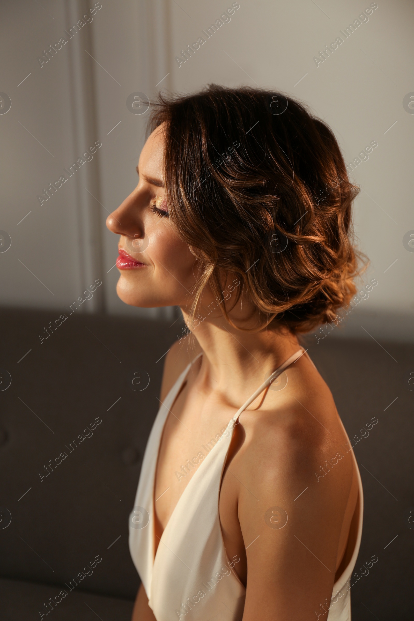 Photo of Elegant young woman with beautiful hairstyle indoors