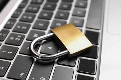 Cyber security. Metal padlock on laptop, closeup