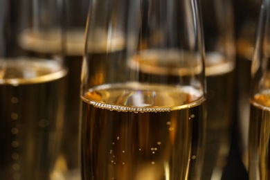 Many glasses of champagne as background, closeup view