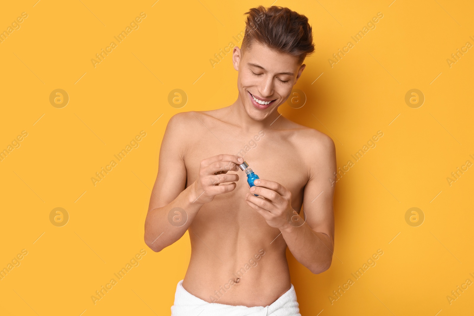 Photo of Handsome man with serum on orange background