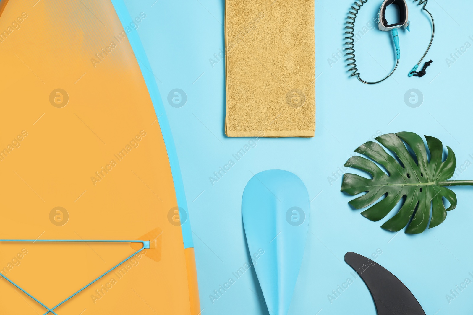 Photo of Flat lay composition with SUP board on light blue background. Water sport