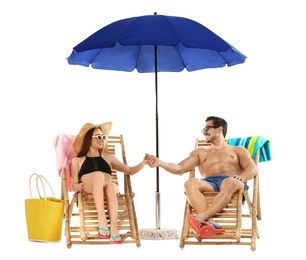 Photo of Young couple with beach accessories on sun loungers against white background