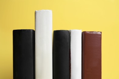 Photo of Collection of hardcover books on yellow background, closeup